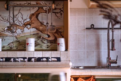 a kitchen counter with two mugs on top of it at Elegant Penthouse LA BALCONATA - Wellness Retreat & Castle View in Tabiano