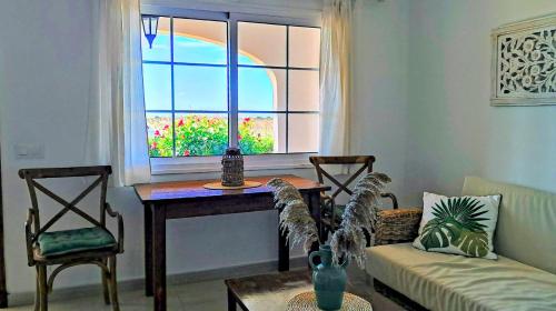 a living room with a table and a window at Mar & Calma in Son Bou