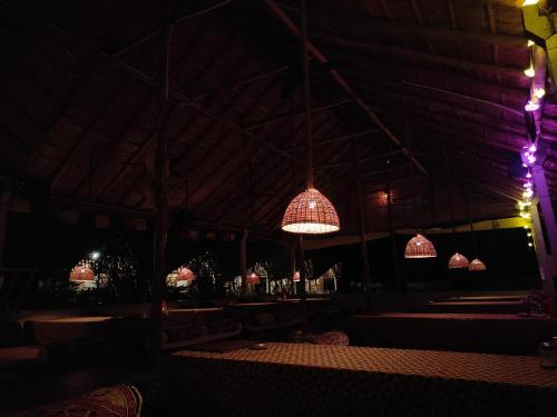 a room with tables and chandeliers in the dark at Crazzy Panda Hampi in Hampi