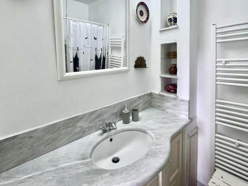 a white bathroom with a sink and a mirror at Pepromeno Boutique in Agios Dimitrios