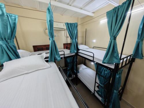 a room with three bunk beds in it at Evara Stays Backpackers Hostel in Kolkata