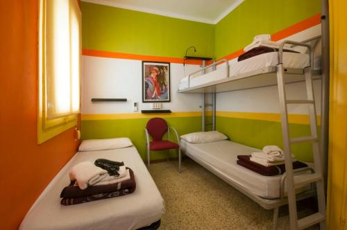バルセロナにあるStudio Hostelの二段ベッド2台と椅子が備わる客室です。