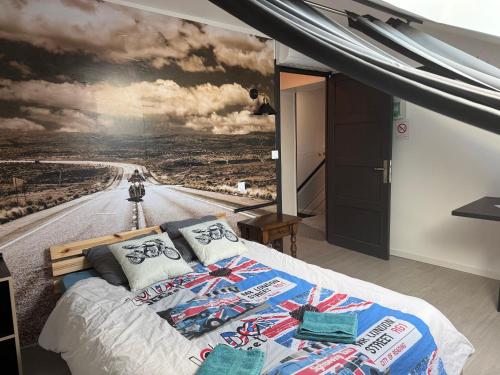 a bedroom with a large painting on the wall at dépendance de la Métairie in Bignan