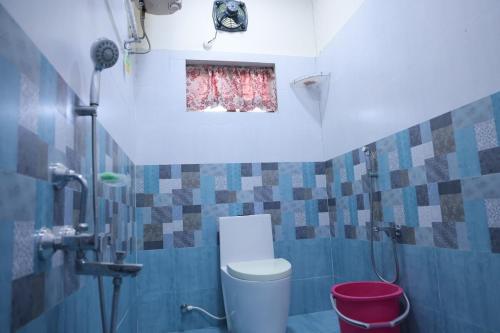 a small bathroom with a toilet and a window at Premium House or Office In Amaravati in Sūriapālem