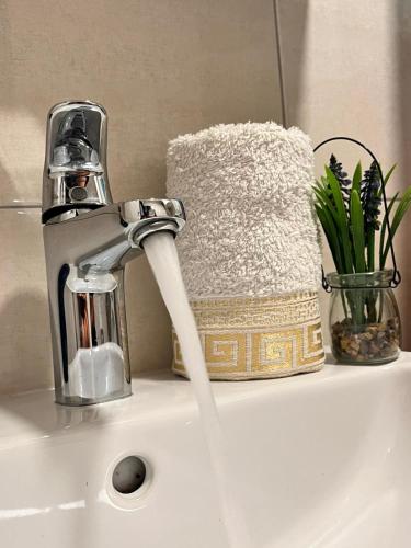 a sink with a faucet with water coming out at Dionis in Veliko Gradište