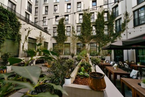 an outdoor patio with tables and plants and a building at Hotel AMANO Grand Central in Berlin