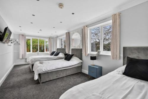 a bedroom with two beds and two windows at The PADhouse in York