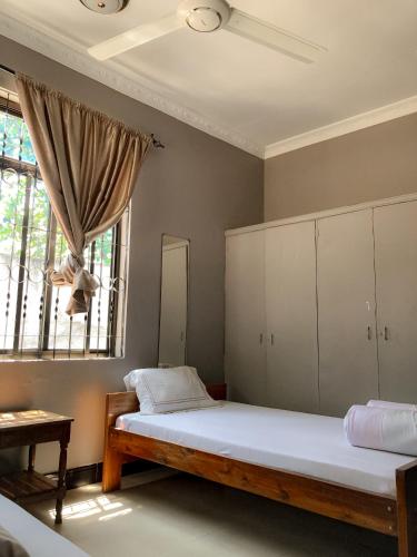 a bedroom with a large bed and a window at Kiusa Badget Hotel in Moshi