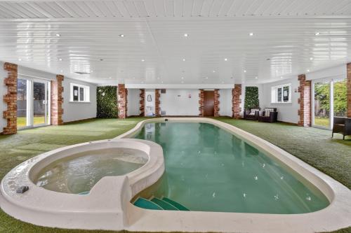 an indoor pool with a hot tub in a large room at The PADhouse in York