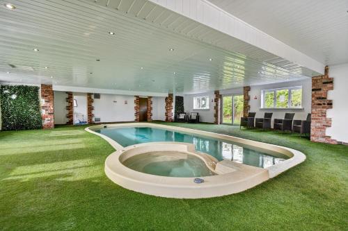 a swimming pool in a large room with green grass at The PADhouse in York
