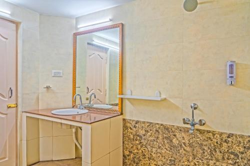 a bathroom with a sink and a mirror at Hotel Mount View in Kodaikānāl