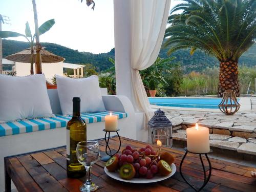 a table with candles and wine bottles on a patio at Villa Aliki in Vasiliki