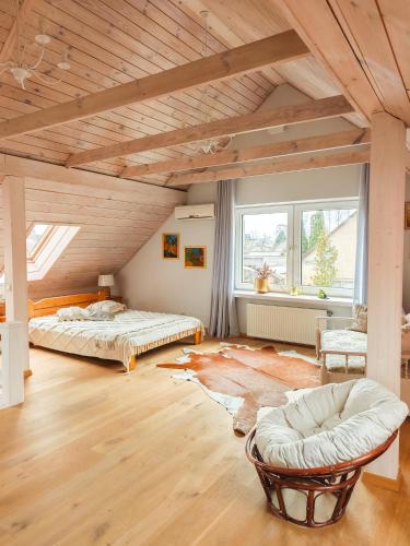 a large room with two beds and a chair at Dorupes House in Liepāja
