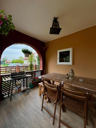 a dining room with a table and a balcony at Demeter Vendégház in Tiszanána