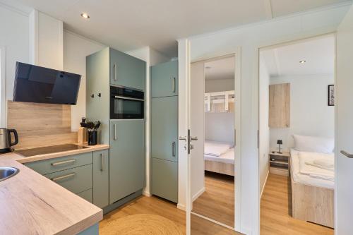 a kitchen with green cabinets and a bed at Ostseecamp Salt & Sea in Scharbeutz