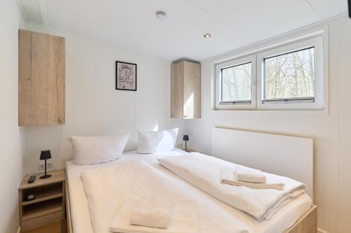 a bedroom with a bed with white sheets and a window at Ostseecamp Salt & Sea in Scharbeutz