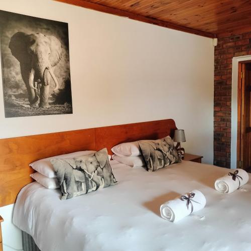 a bedroom with two beds and an elephant picture on the wall at The Bay Inn in Port Elizabeth