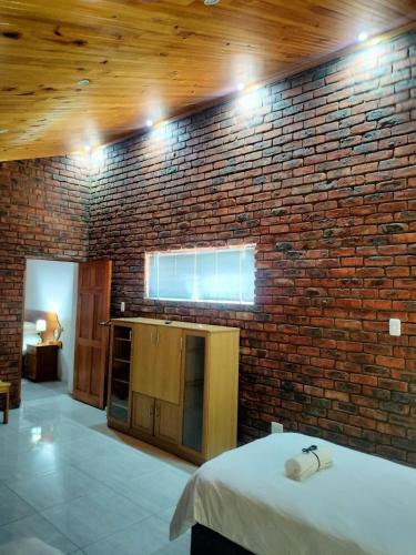 a room with a brick wall with a bed in it at The Bay Inn in Port Elizabeth