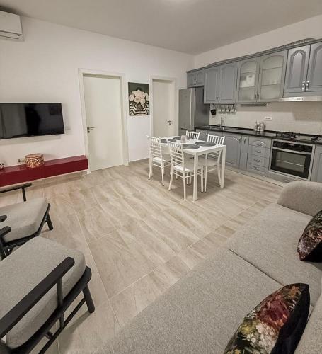 a living room with a table and a kitchen at VERA apartament in Fushë-Draç