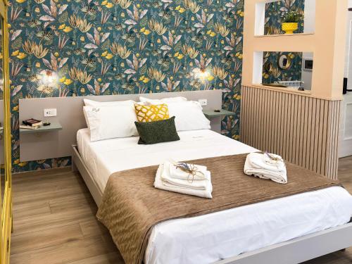 a bedroom with two beds and a floral wallpaper at Dimora Alfinito in Salerno