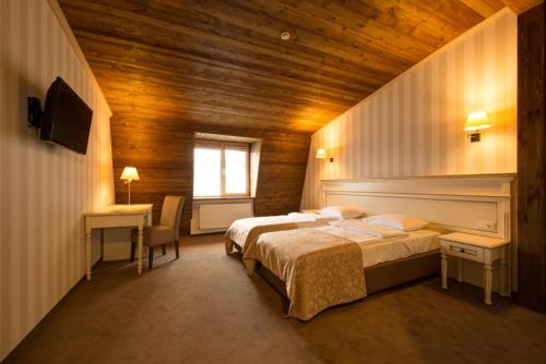 a bedroom with two beds and a desk and a window at Premier Geneva Hotel in Odesa