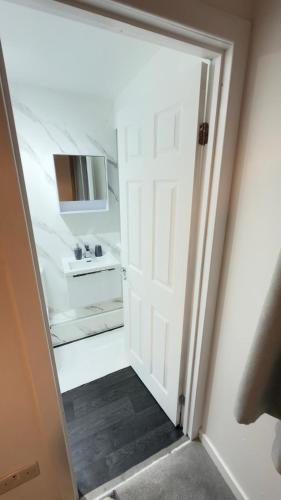 a door leading into a bathroom with a sink at Suite 3 En-suite Room with Double Bed in Edinburgh