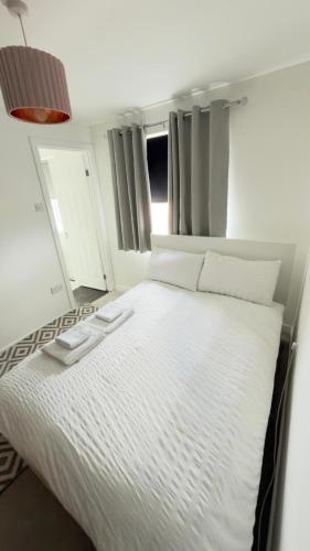 a large white bed in a room with windows at Suite 3 En-suite Room with Double Bed in Edinburgh