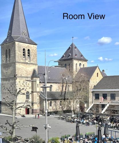ein großes Gebäude mit einem Turm und einer Kirche in der Unterkunft Hotel chic room in Heerlen
