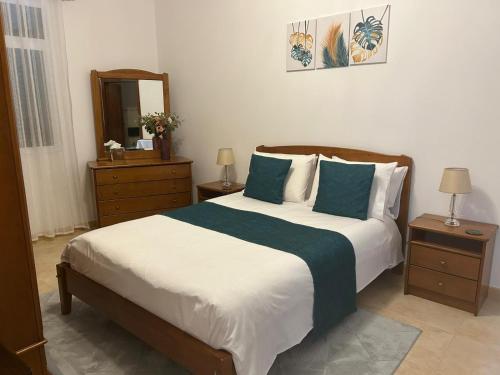 a bedroom with a large bed with blue pillows at Casa do Pico in Ribeira Brava