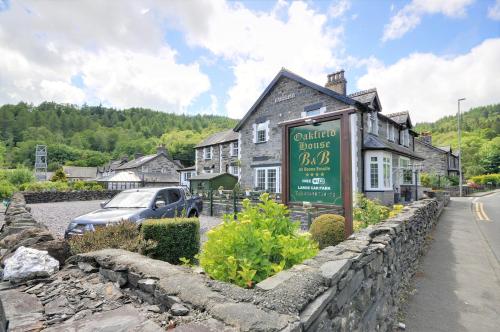 a sign in front of a building in a village at Oakfield House Bed and Breakfast in Betws-y-coed