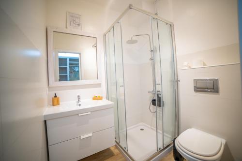 a bathroom with a shower and a toilet and a sink at Saltline Surf House Ericeira in Ericeira