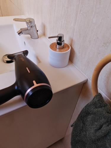 a hair dryer sitting on a bathroom sink at Eiras AL Ilha da Madeira in Santa Cruz