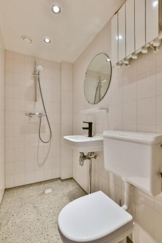 a bathroom with a toilet and a sink and a mirror at Bright City Retreat near Center & RAI in Amsterdam
