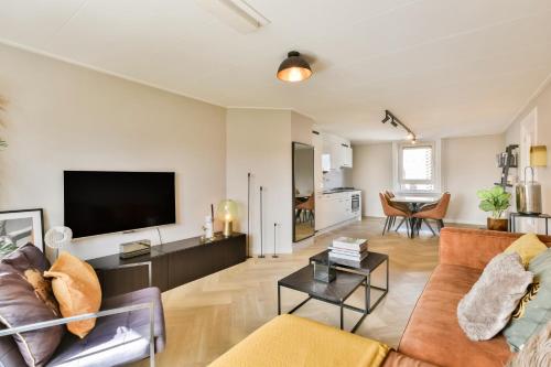 a living room with a couch and a flat screen tv at Bright City Retreat near Center & RAI in Amsterdam