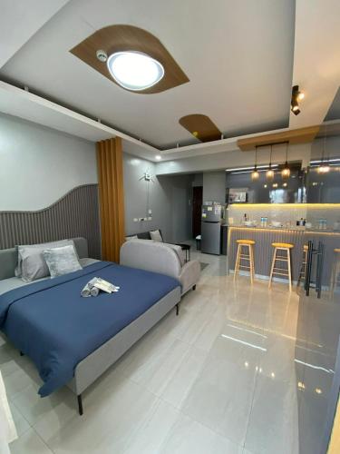 a bedroom with a blue bed and a kitchen at Ohhlala Cozy Corner at Royal Oceancrest Mactan in Mactan Island