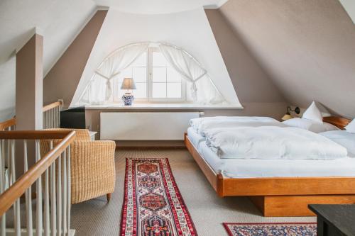 a attic bedroom with two beds and a window at Haus am Kiel in Ahrenshoop