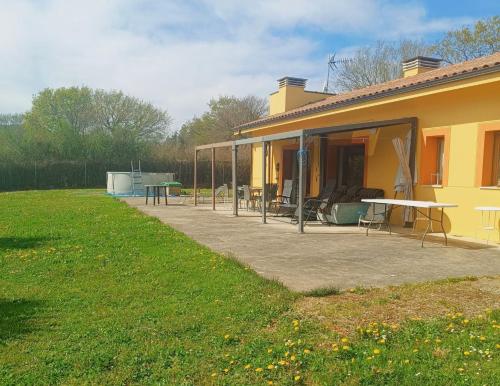 a yellow house with a patio and a table at My Reyna in San Miguel