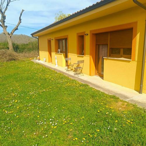 a yellow house with tables and chairs in a yard at My Reyna in San Miguel