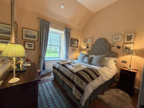 a bedroom with a bed and a desk and a window at Barns Studio in Peebles