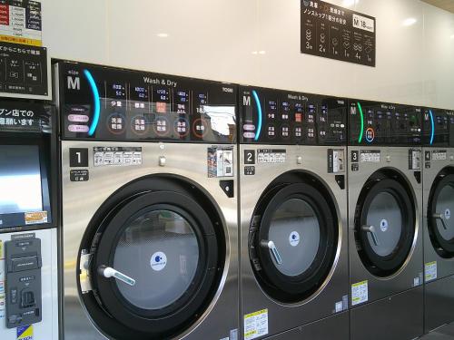 three washing machines are lined up in a laundrette at House of the Rising Sun in Takatsuki
