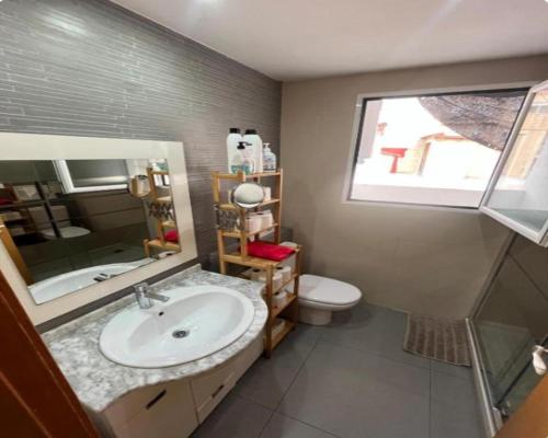 a bathroom with a sink and a toilet and a window at ÁTICO HOME y Garaje, Algemesi Home in Algemesí