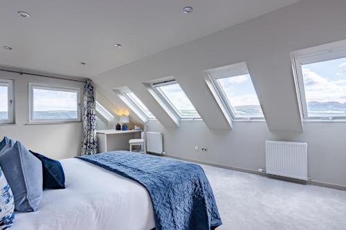 a bedroom with a large bed with windows at Fern View in Inverness