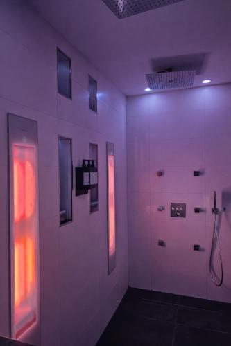 a bathroom with white walls and red lights at Bed & Wellness Angie in Almere