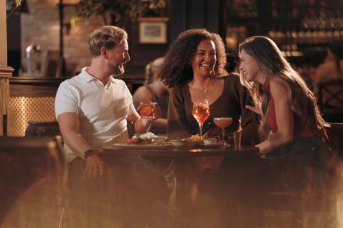 a group of people sitting at a table in a restaurant at The Wordsworth, Grasmere - The Inn Collection Group in Grasmere