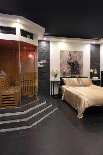 a bedroom with a large bed and a bathroom at Bed & Wellness Angie in Almere