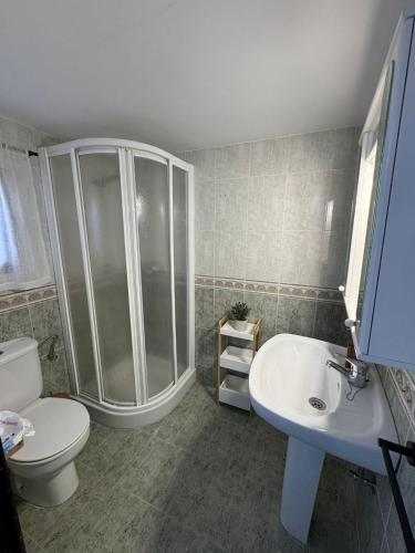a bathroom with a shower and a toilet and a sink at Casa Rural Hortensia in Zuheros