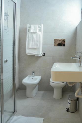 a bathroom with a sink and a toilet and a shower at Hotel La Casa Del Pellegrino in SantʼAnastasia