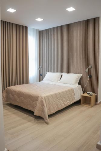 a bedroom with a large bed and a wooden floor at Hotel La Casa Del Pellegrino in SantʼAnastasia