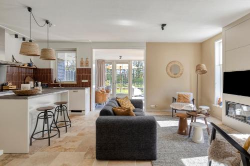 a living room with a couch and a kitchen at Groenendijk Verhuur Vakantiewoning Casa Iris in Burgh Haamstede