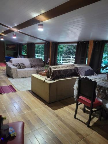 a living room with a couch and a table at Pousada Recanto Dos Pássaros in Colégio